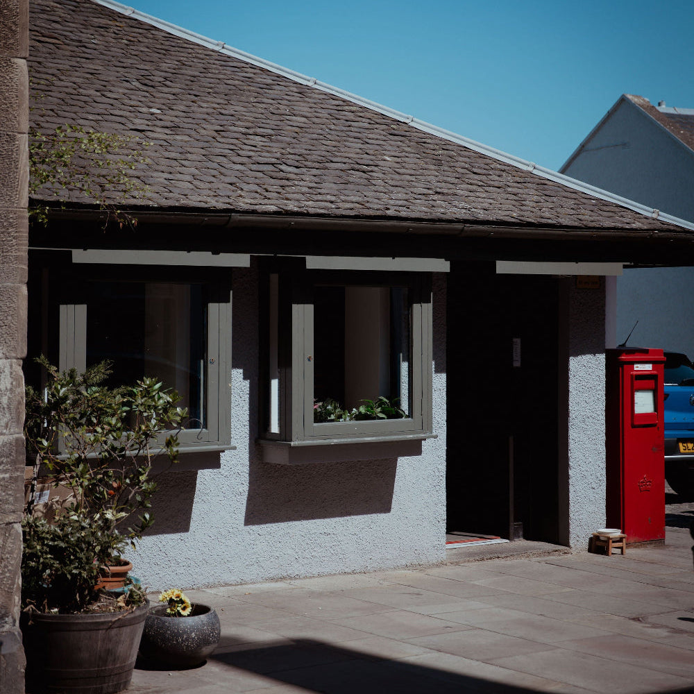 Small building with a red postbox on a sunny day