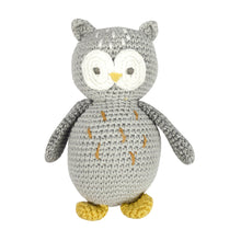  A crocheted rattle in the shape of an owl. Oliver has a grey body with gold details. Big white eyes, a yellow beak and yellow feet.