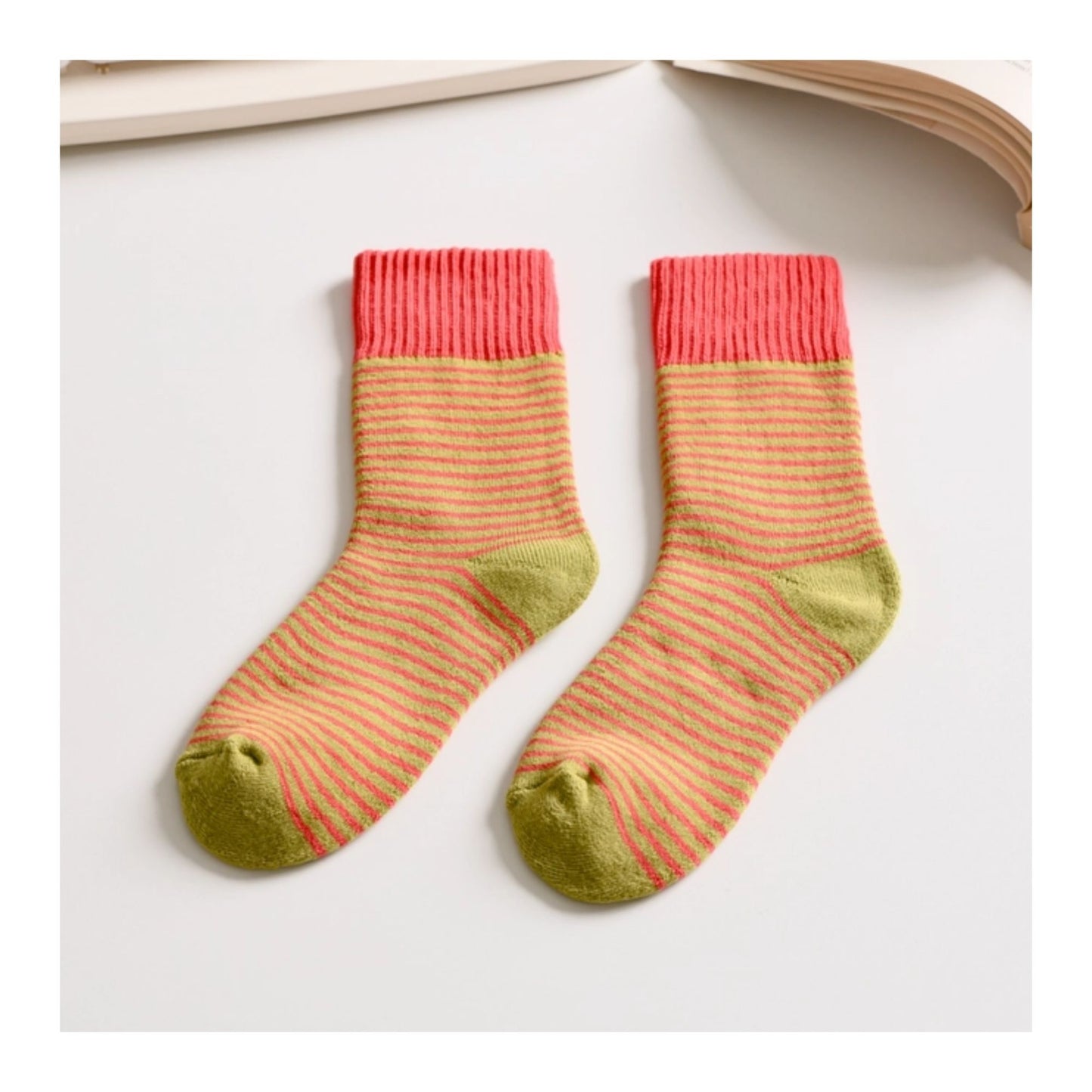 Pair of striped socks with pink top and green toes on a white background