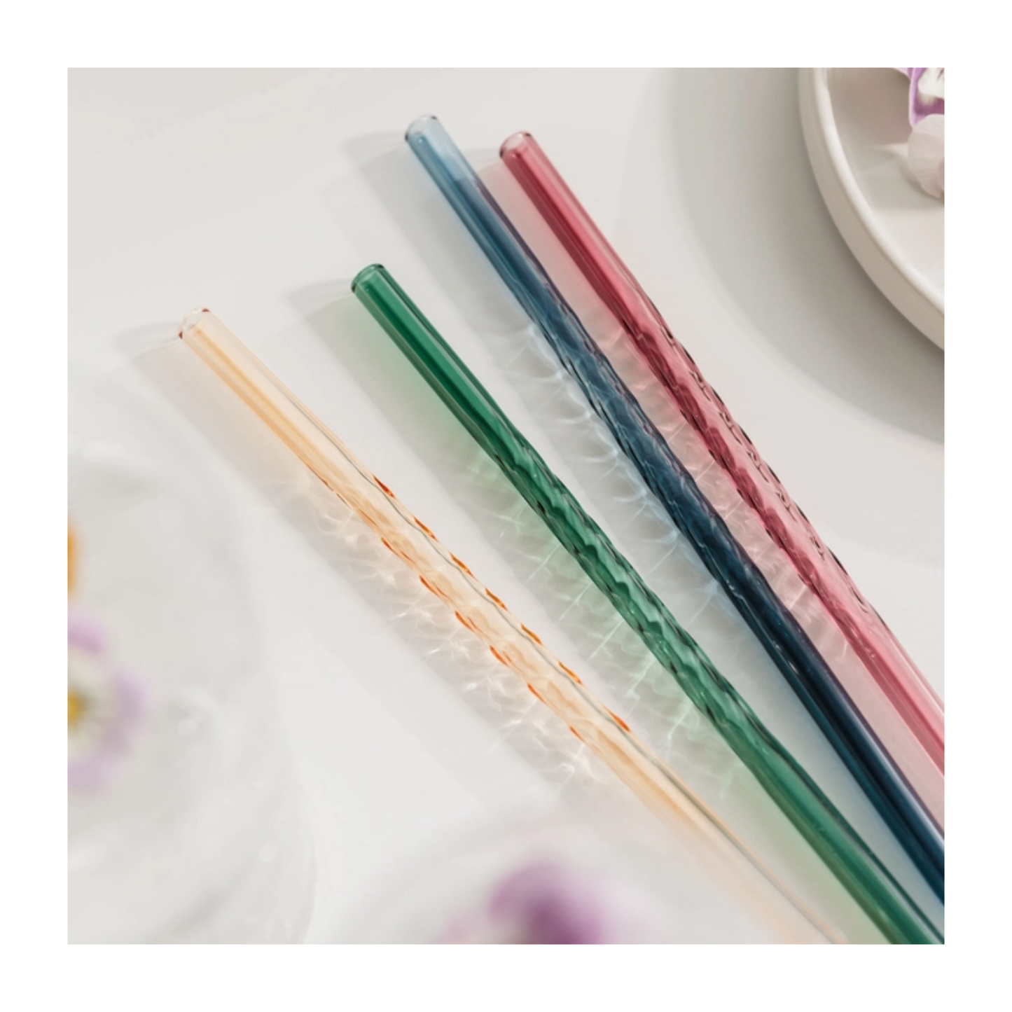 Set of colorful straws on a white surface