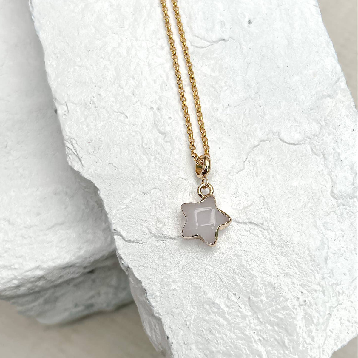 Necklace with a star-shaped pendant on a textured white surface