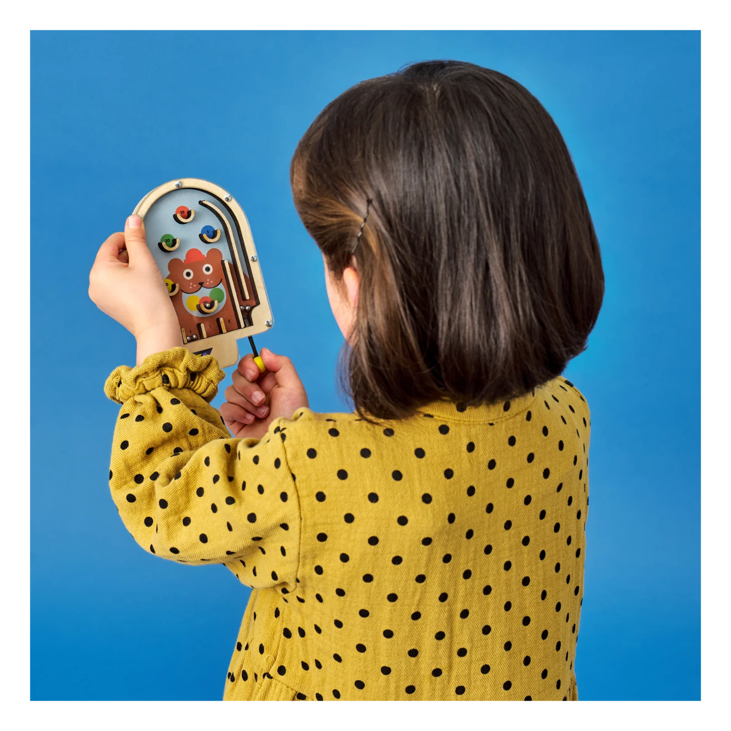 Child holding a toy with a blue background