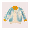 A soft knitted children's cardigan with scalloped striped pattern in blue and cream with yellow collar and cuff.