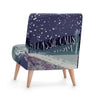 An illustrated occasional chair from Tori Gray of Harbour Lane Studio. The chair is upholstered in Tori's 'Bothy Folk Song' design, featuring a crescent moon on the front facing chair back and a bothy on the seat. The text read over the design, 'Across the Moonlit Heather, My Lassie Calls As I Roam. Tis Soon We'll be Together in that Heaven We Call Home'.