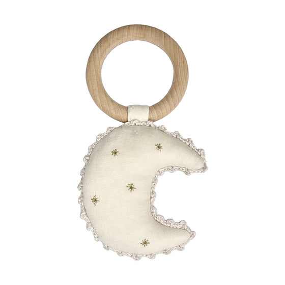A handcrafted baby rattle made from 100% cotton and a wooden ring. The rattle is in the shape of a crescent moon in cream fabric with gold detailing.