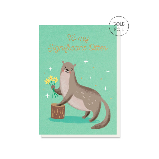 A greeting card featuring gold foil and an illustrated design of an otter holding a bunch of flowers. Text says 'To my Significant Otter'