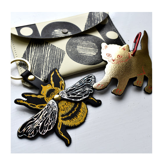 Yellow and silver metallic leather bee key fob with cat bag tag and shapes purse, all by Ark 
